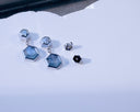The Hex Effect earrings in 18K white gold shown at a three-quarter angle, with velvety blue hexagonal Montana sapphire slabs, hexagon diamond tops and custom friction backs.