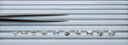 Curation of ten loose diamonds in a diamond tray with tweezers: heart, elongated criss-cut cushion, Old European cut, oval brilliant, elongated cushion brilliant, round brilliant, step-cut pear, emerald cut, round brilliant, and step-cut hexagon.